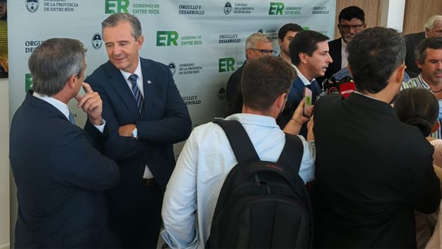Detrás de escena en Entre Ríos. Adán Bahl y Guillermo Michel esperando que termine de hablar ante la prensa Mauricio Colello.