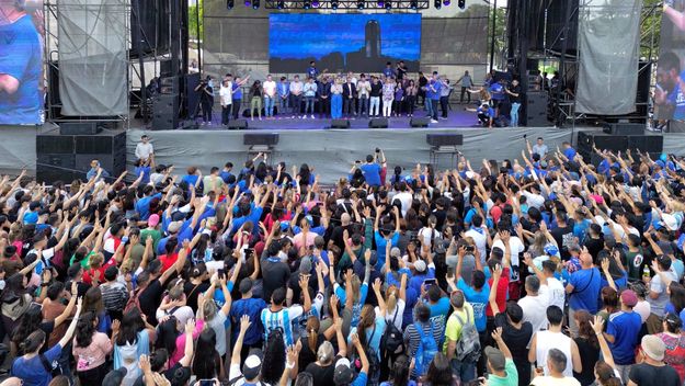 Maximiliano Pullaro, Gisela Scaglia, Pablo Javkin y otros dirigentes políticos oran desde el escenario junto a los fieles.