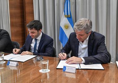 El gobernador de Chubut, Ignacio Torres, y el ministro Toto Caputo firman la quita de retenciones al crudo.