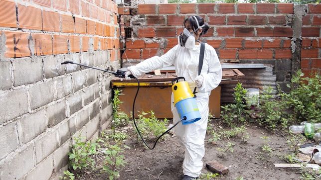 Personal municipal fumigando para evitar la reproducción del mosquito que transmite el virus del dengue.