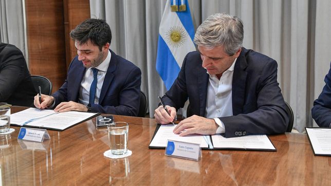 El gobernador de Chubut, Ignacio Torres, y el ministro Toto Caputo firman la quita de retenciones al crudo.
