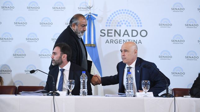 Héctor Daer, jefe de la CGT, saluda a Ezquiel Atauche y Bartolomé Abdala, senadores  de La Libertad Avanza, durante  el debate de la ley ómnibus. 