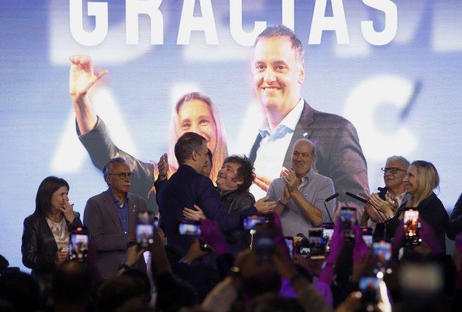 Manuel Adorni y Javier Milei abrazados en el búnker de La Libertad Avanza.