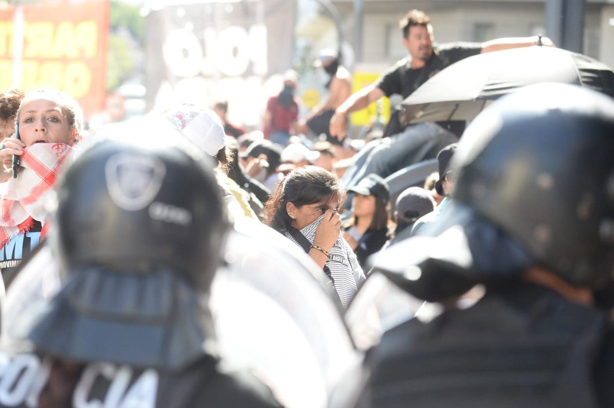 Policía de la Ciudad arroja gas lacrimógeno y una manifestante se cubre la boca (Fuente: AG).