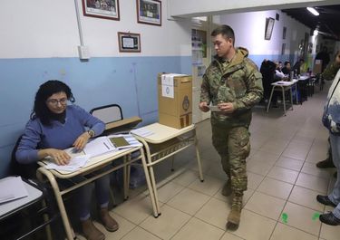 Un efectivo militar vota en una mesa en Viedma