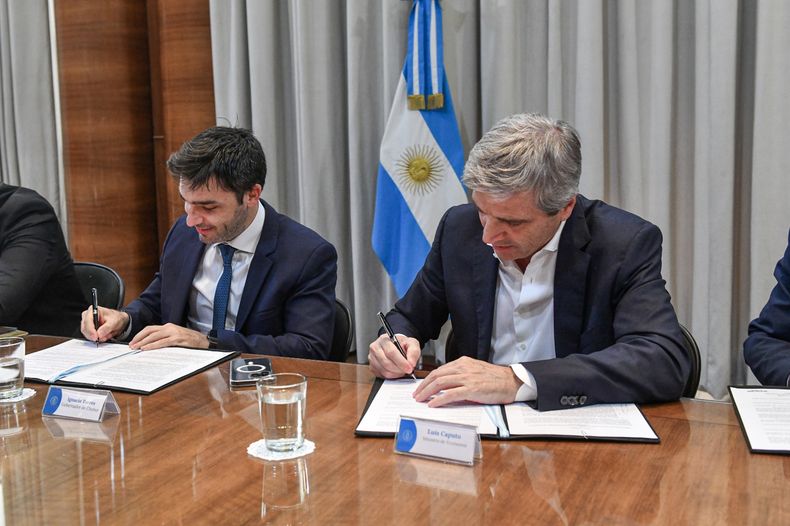 El gobernador de Chubut, Ignacio Torres, y el ministro Toto Caputo firman la quita de retenciones al crudo.