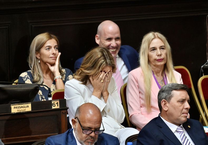 Florencia Arietto se tapa la cara mientras escucha a Kicillof en la Asamblea Legislativa.