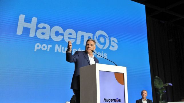 Llaryora desde el atril en La Rural de Palermo. Atrás, la mirada de Juan Schiaretti.&nbsp;